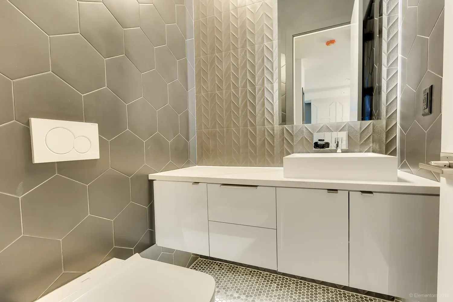 Powder room with hexagon tile walls, white vessel sink, and floating vanity in Vancouver