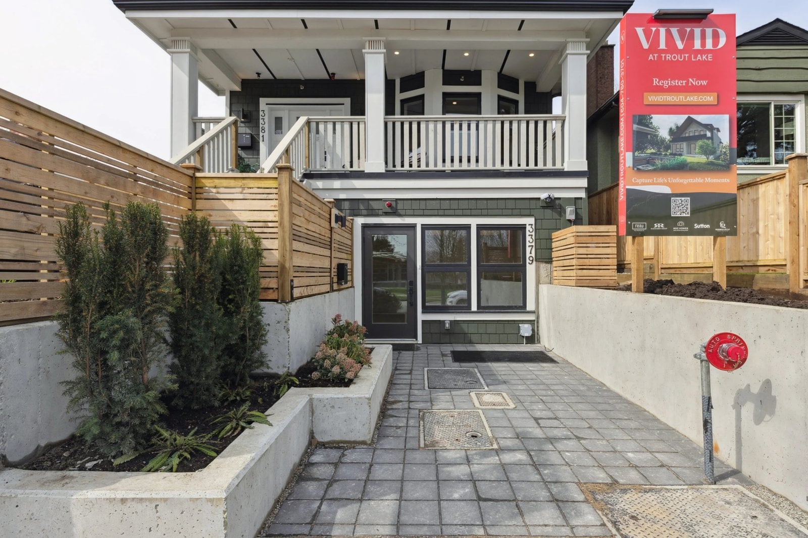 Vancouver green and white two story home entrance with covered porch and paved walkway