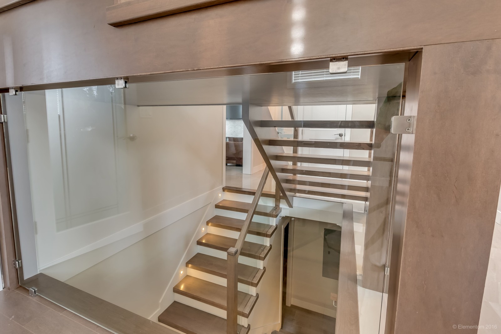 Vancouver home floating wood staircase with glass railing and open riser design