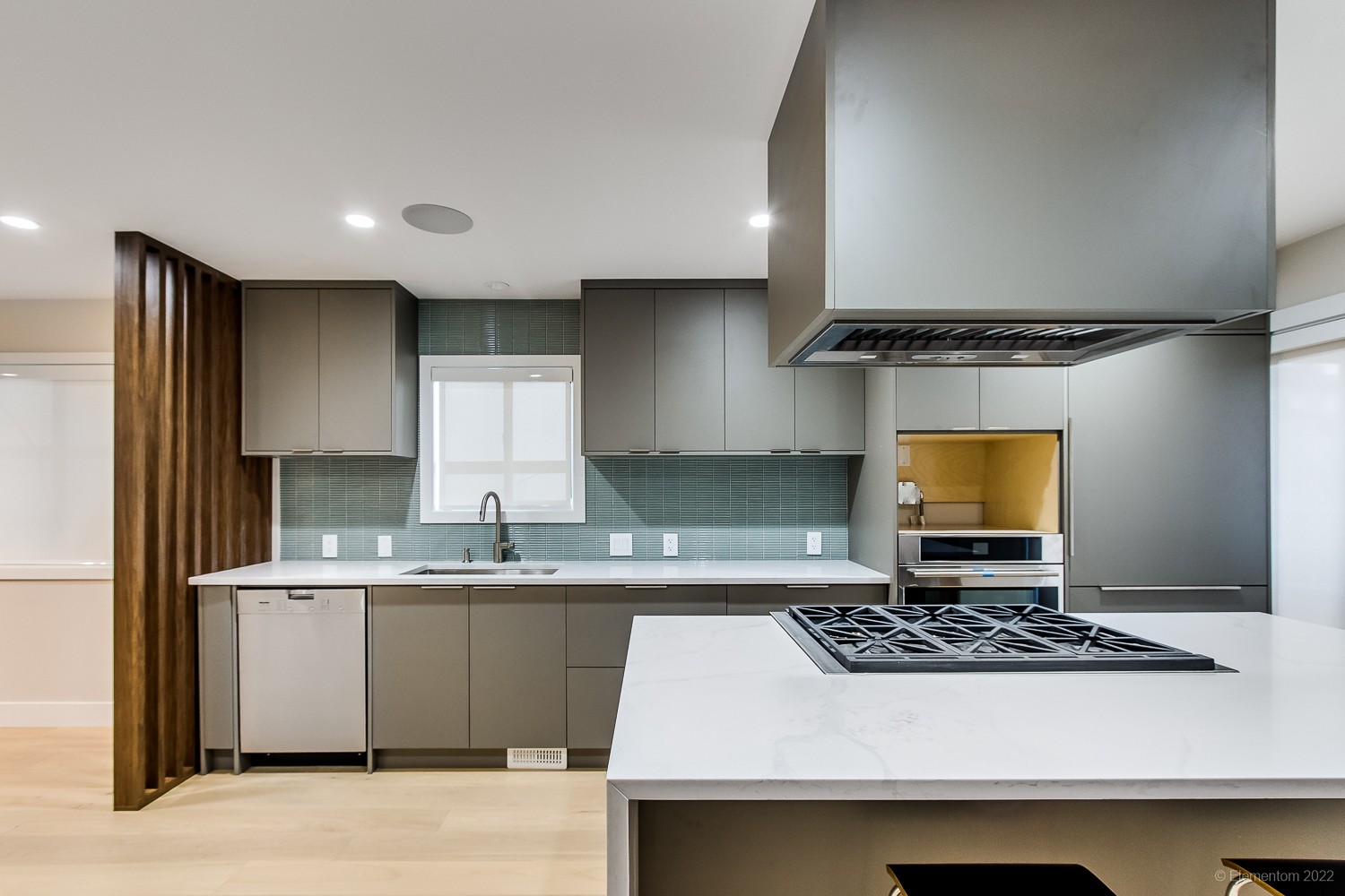 Vancouver kitchen with gray cabinetry, teal tile backsplash, and gas range top island