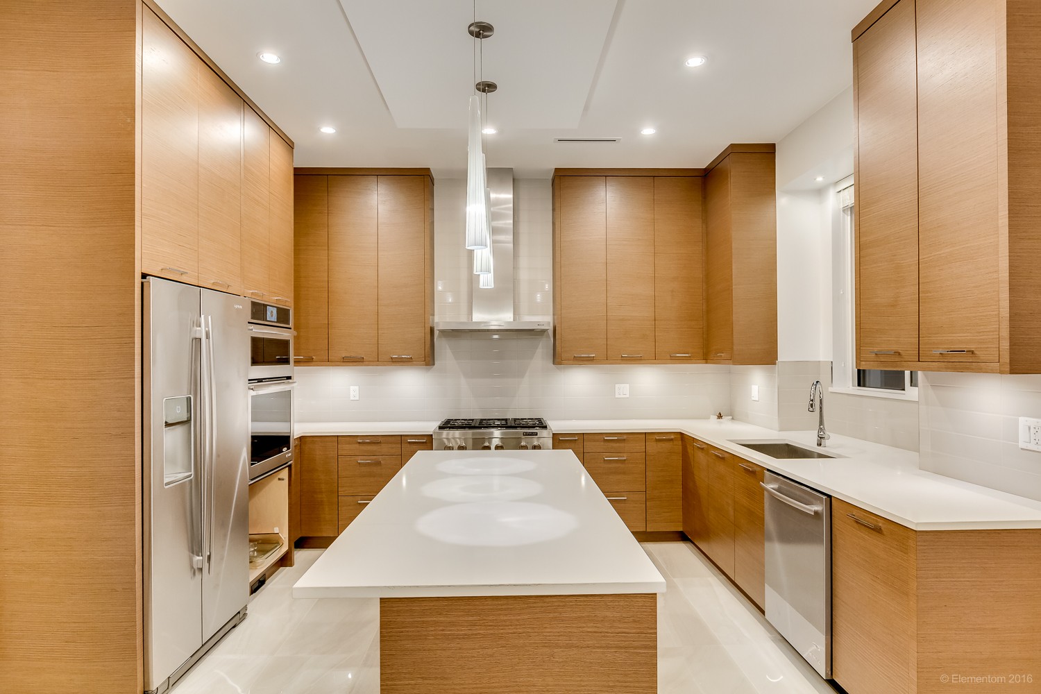 Vancouver kitchen with light wood cabinetry, white quartz island, and stainless steel appliances
