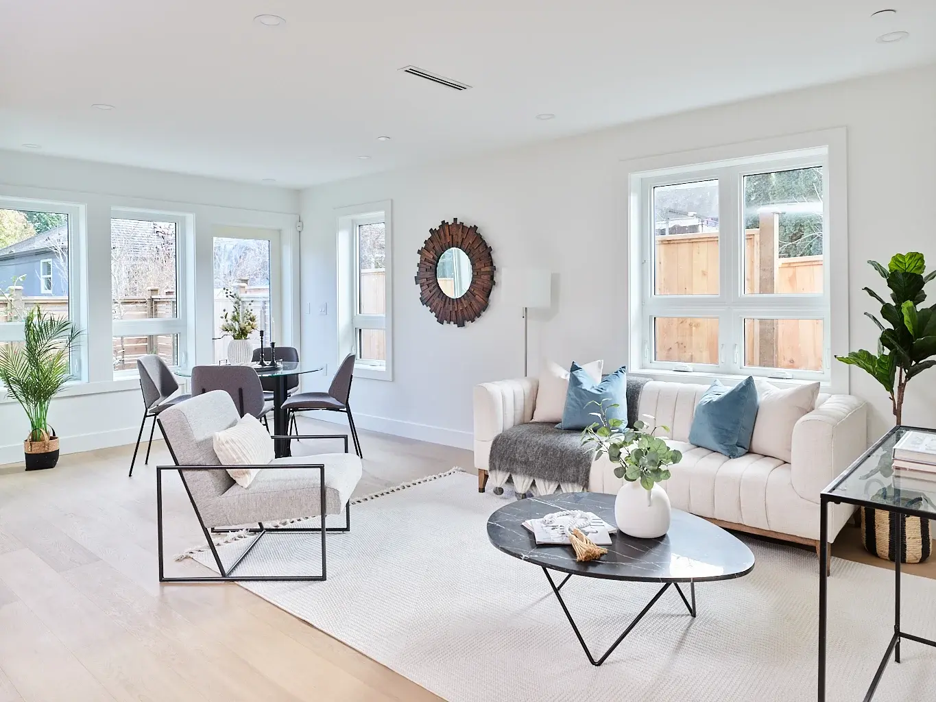 Vancouver living room with cream sofa, blue accent pillows, and round wood mirror