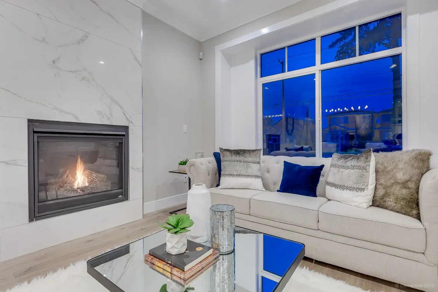 Vancouver living room with marble fireplace, cream sofa, and navy blue accent pillows