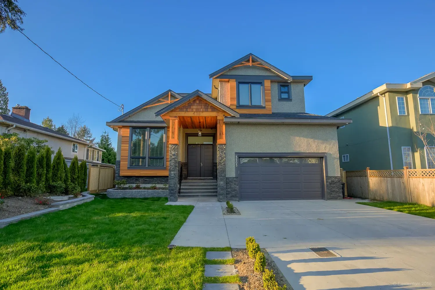 Vancouver two story home exterior with cedar accents, stone veneer, and attached double garage