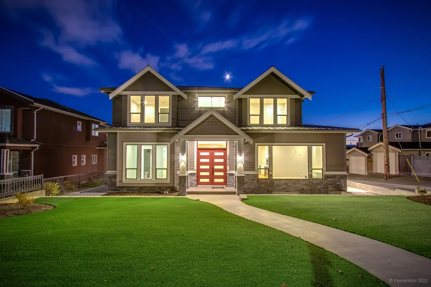 Vancouver two story home exterior with double red front doors and covered entry at twilight