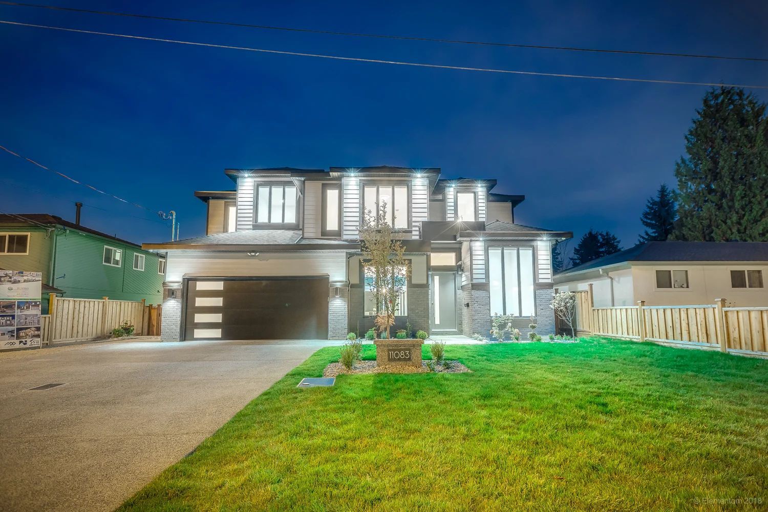 Vancouver two story home exterior with illuminated windows and landscaped front yard at twilight